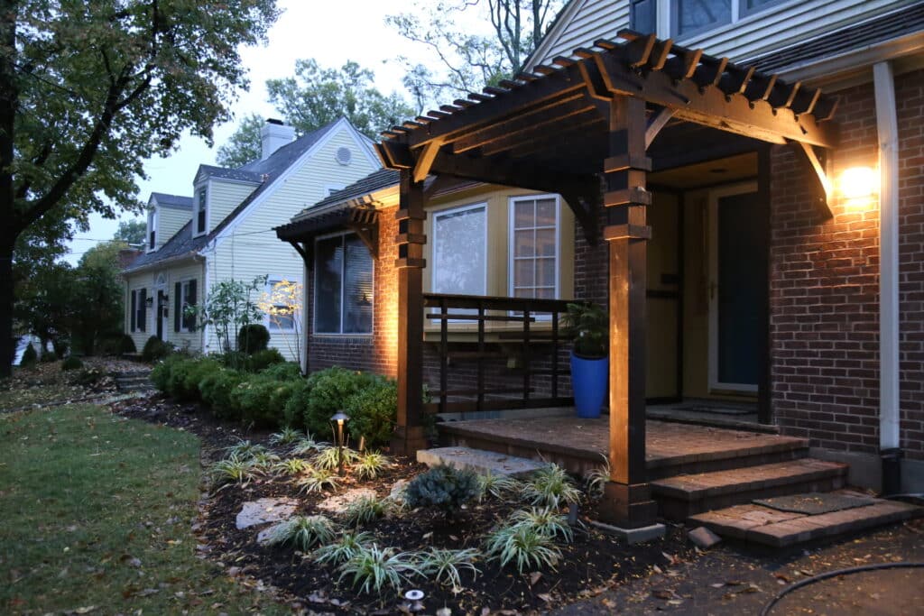 After - New landscape plantings and a custom cedar porch make this home welcoming and unique